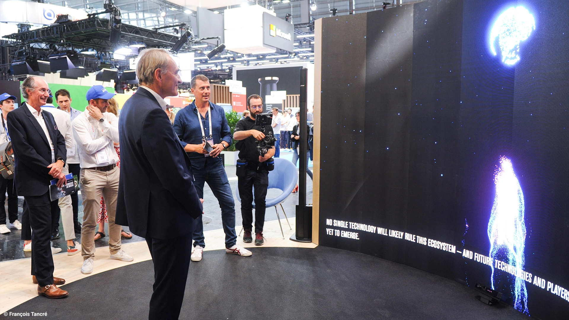 A person watches on the LED screen his digital avatar flying towards the earth during the Beyond Metaverse experiment