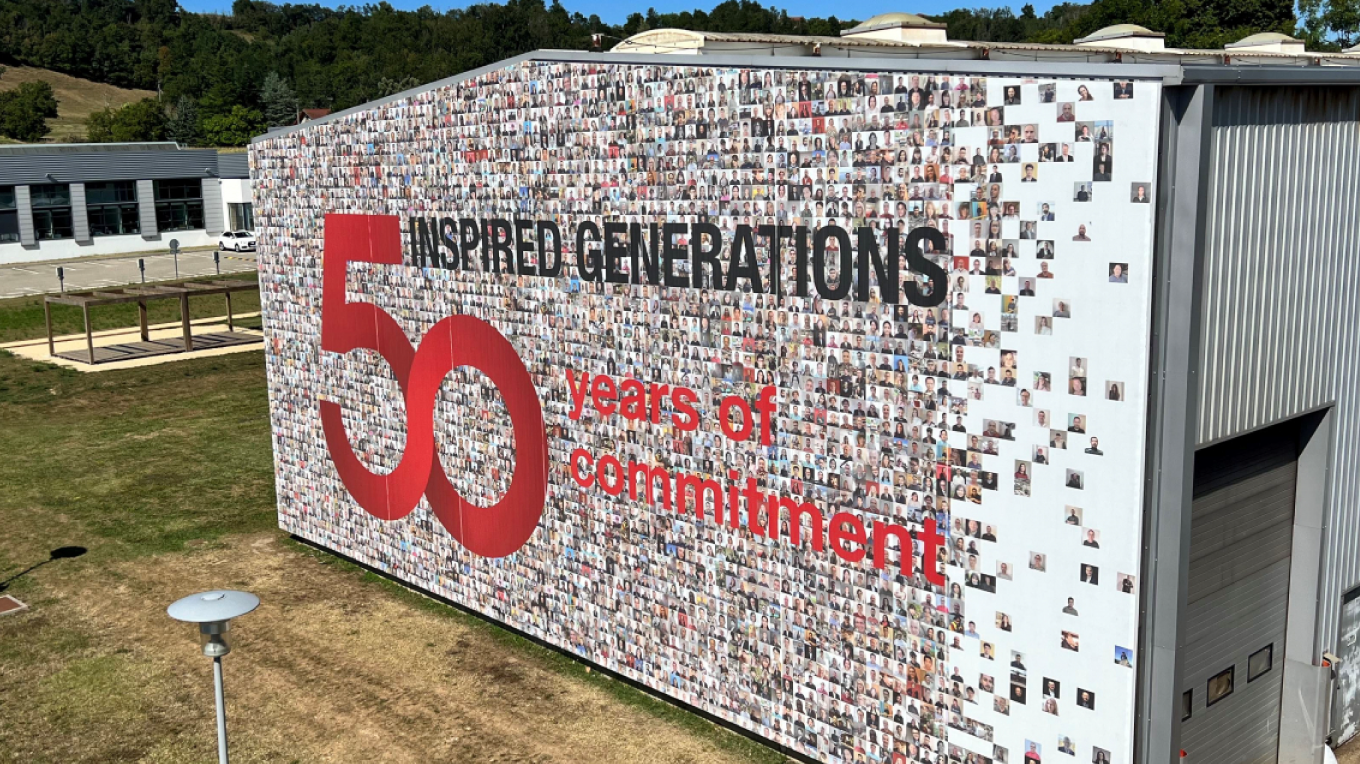 A monumental human photo mosaic printed on the facade of the headquarters, representing the 50-year history of the Serge Ferrari Group and including photos of employees.